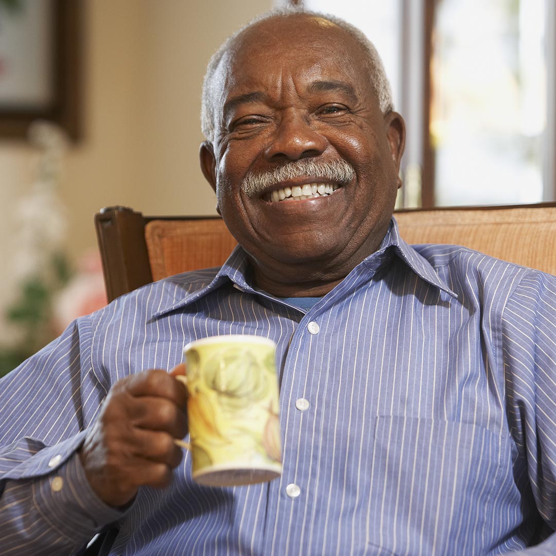 Happy senior man holding a cup of coffee