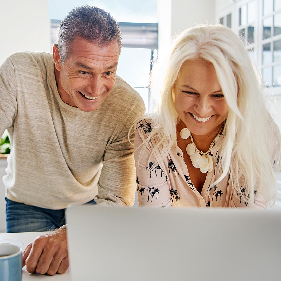 Happy middle-aged couple using a laptop