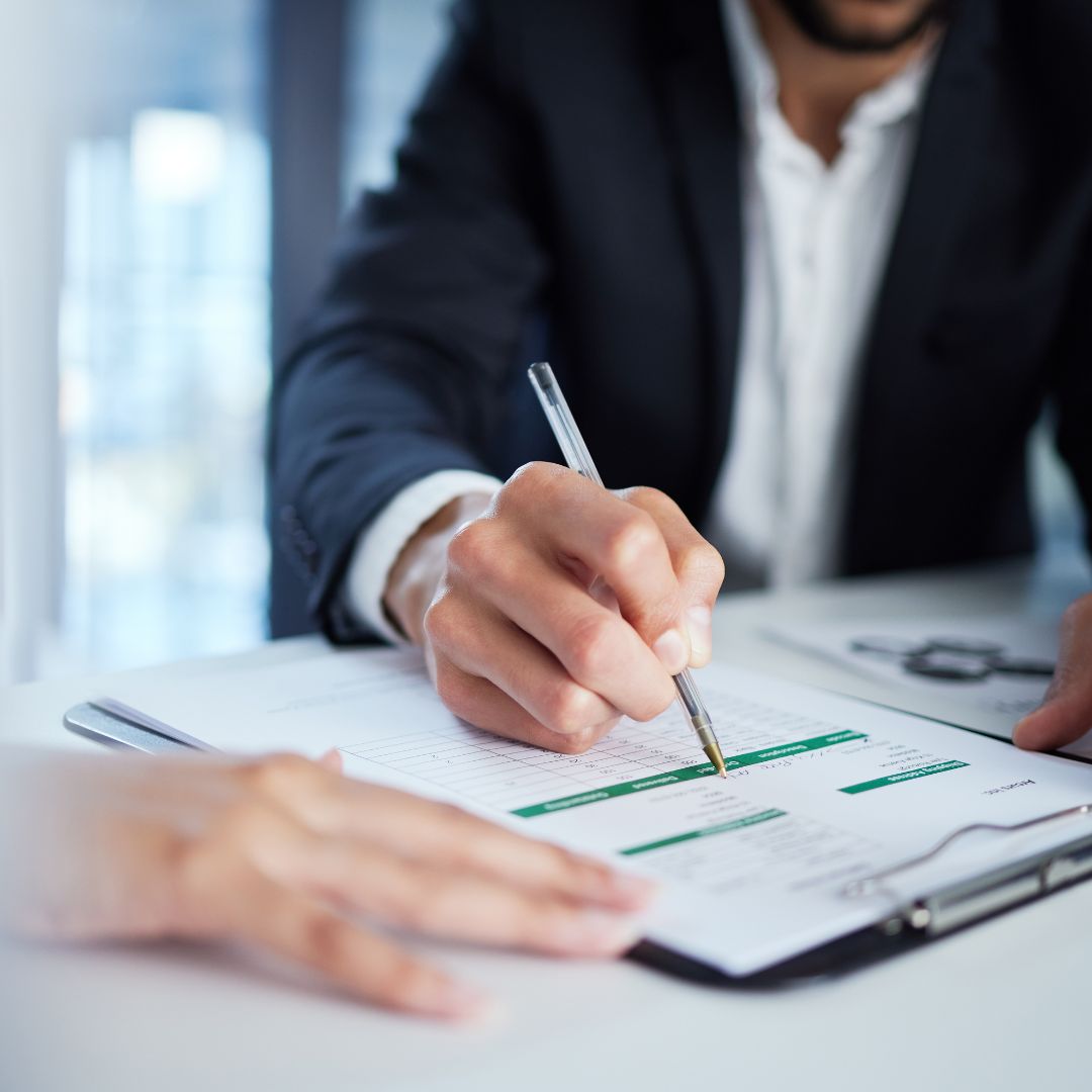Close up of a bussinessman writing on financial documents