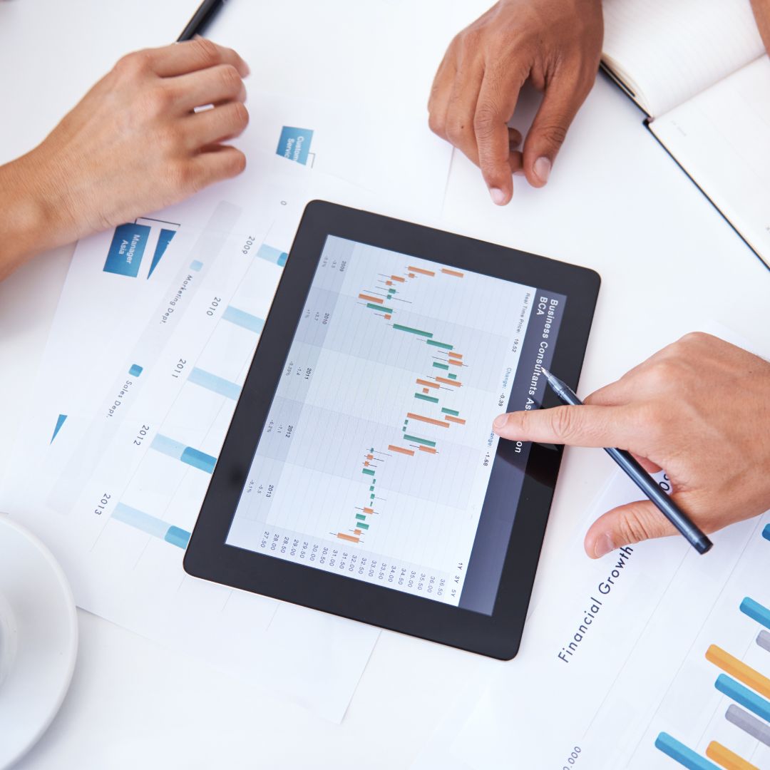 close up of a desk with a tablet with stock market graphs