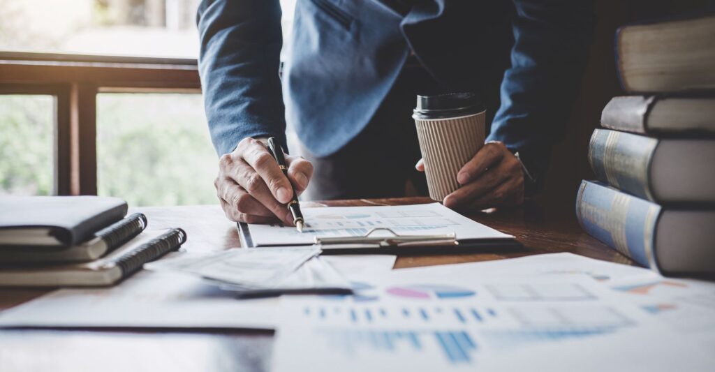 Close up of a businessman's desk while he writes on financial documents