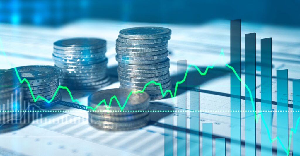 close up of stacks of coins on documents with an overlay of graphs