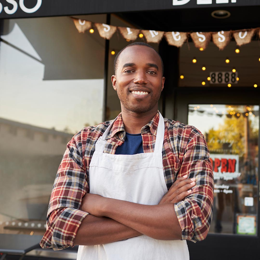 smiling business owner in front of his busines