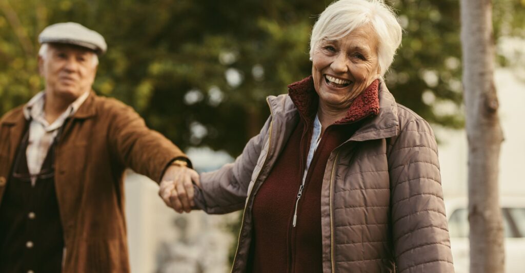 senior couple holding hands and smiling