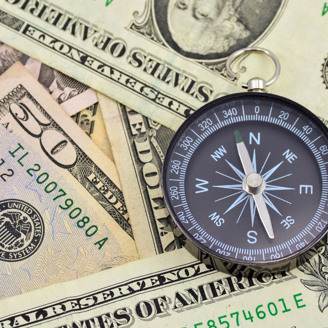 compass on top of money