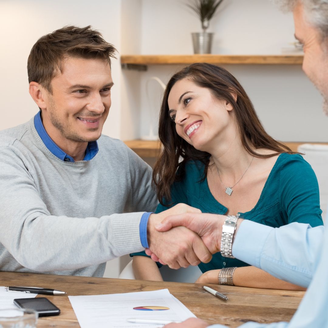 clients talking to their financial planner and shaking hands