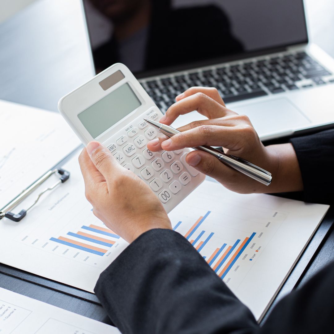a person using a calculator while looking at charts
