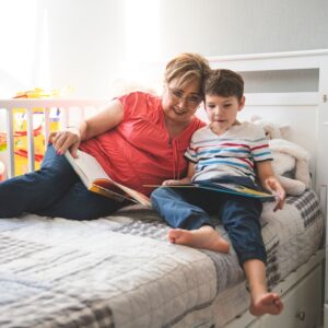 grandmother reeds books with grandchild sitting next to her