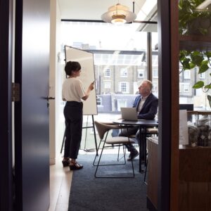 employees work together in meeting room with white board