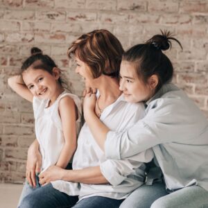 woman with 2 young girls embraced together