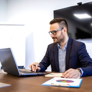 Person review a graph and looking at laptop