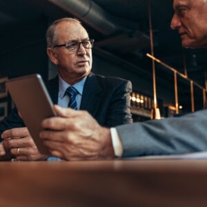 man in suit stands beside another man