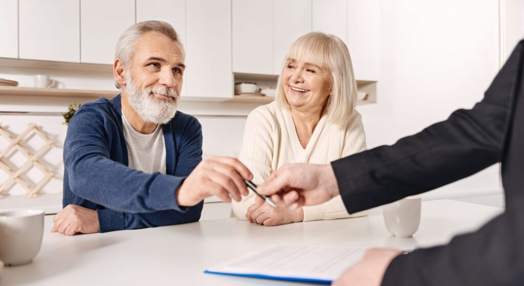 Couple signing documents with financial advisor